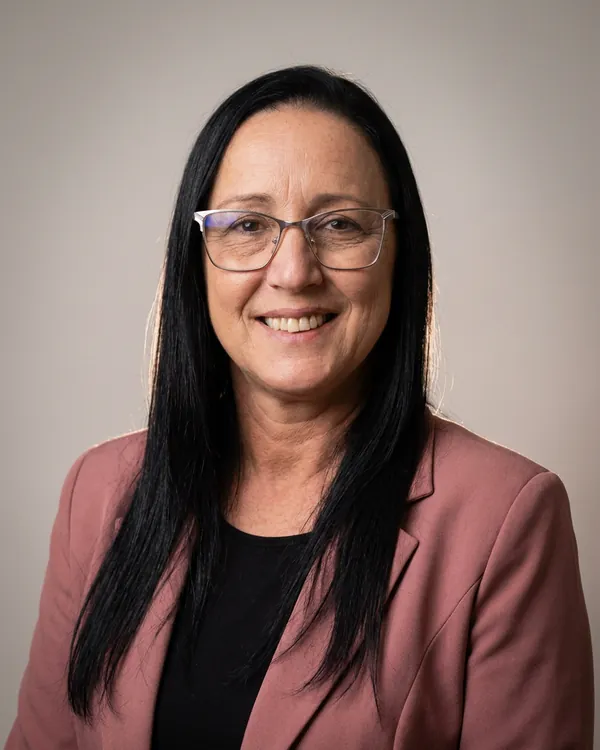 Ana Gomes de blazer rosa, consultora credenciada Cora Empresas